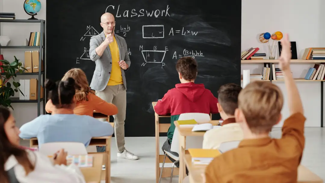 Image of a school teacher with pupils in a classroom environment.