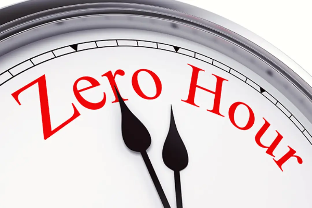 Close up image of a clock face with zero hour written in red in place of the numbers on the clock